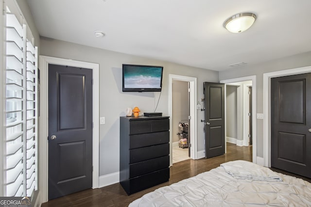 bedroom featuring baseboards and dark wood-type flooring