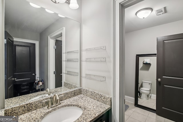 bathroom featuring toilet, visible vents, baseboards, vanity, and tile patterned floors