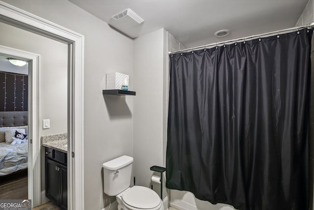 bathroom with toilet, curtained shower, vanity, and visible vents