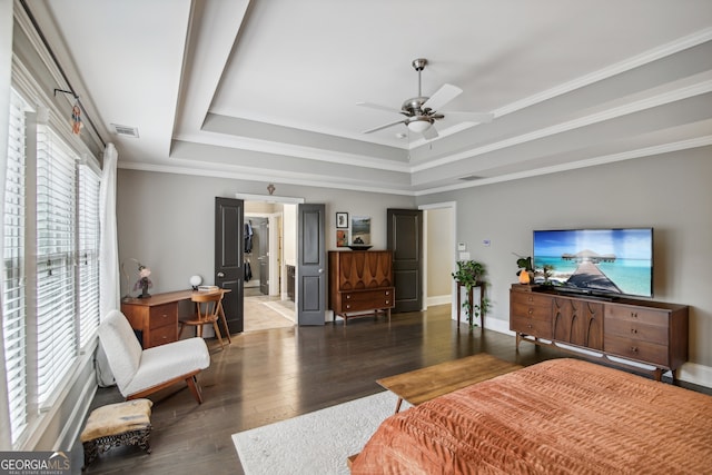 bedroom featuring baseboards, visible vents, a tray ceiling, and wood finished floors