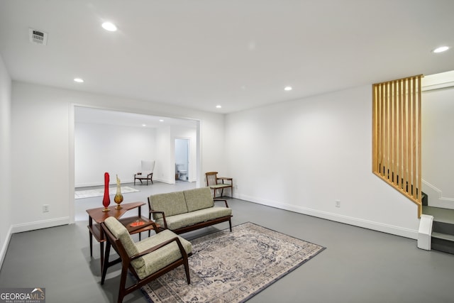 sitting room with concrete flooring, baseboards, visible vents, and recessed lighting