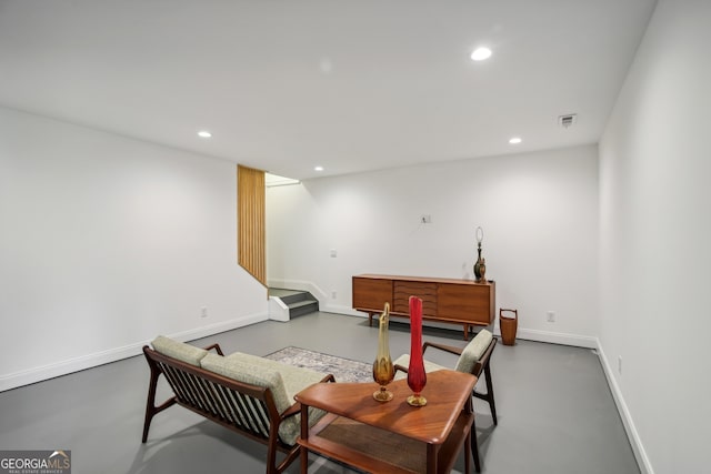 living area with concrete floors, visible vents, and recessed lighting