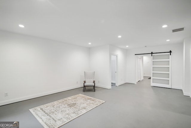 sitting room with recessed lighting, visible vents, finished concrete flooring, and a barn door