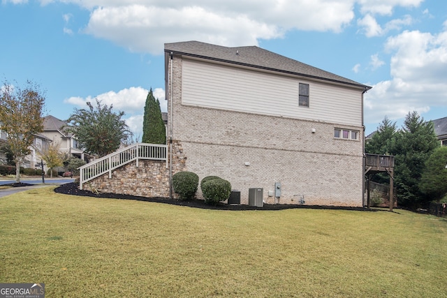 view of side of home with a lawn and brick siding