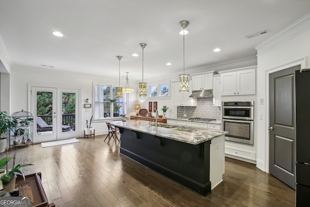 kitchen with under cabinet range hood, visible vents, stainless steel appliances, and ornamental molding