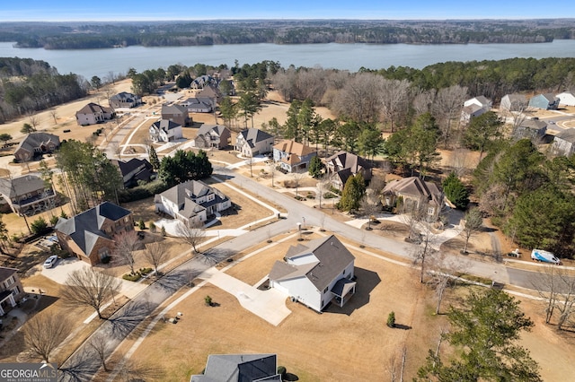 bird's eye view featuring a residential view, a water view, and a wooded view