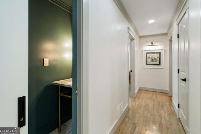 corridor with visible vents, baseboards, light wood-style flooring, crown molding, and recessed lighting