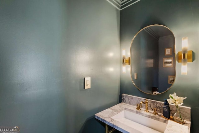 bathroom featuring crown molding and a sink