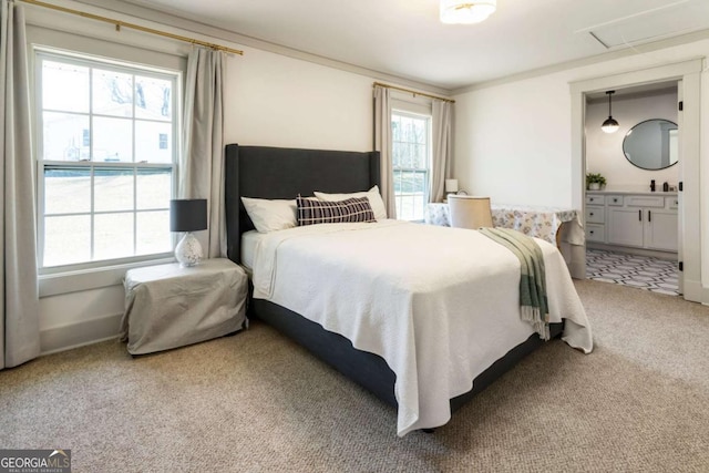 carpeted bedroom featuring ensuite bath, ornamental molding, and baseboards