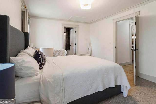 bedroom featuring baseboards, attic access, and light colored carpet