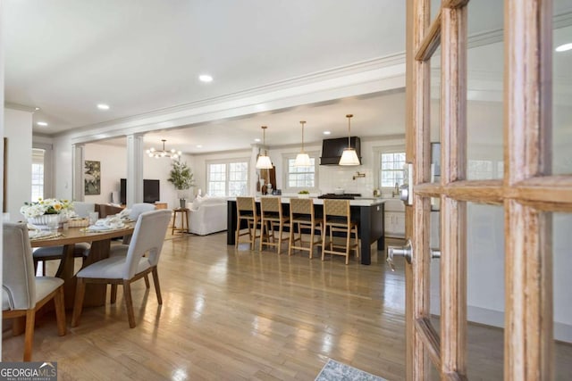 dining room featuring crown molding, recessed lighting, plenty of natural light, and wood finished floors