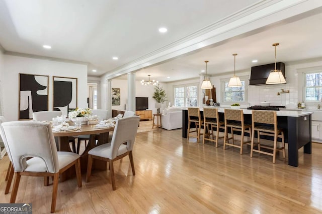 dining room featuring light wood-style flooring, ornamental molding, a notable chandelier, and recessed lighting