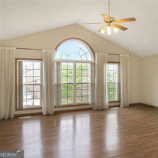 empty room featuring lofted ceiling and wood finished floors