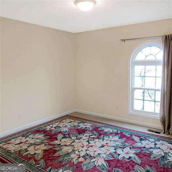 carpeted empty room with ceiling fan and baseboards