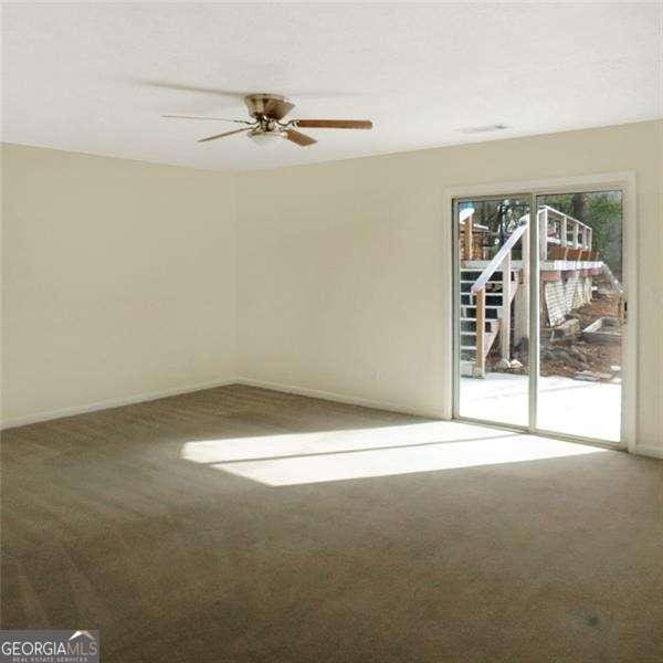 spare room featuring a ceiling fan and carpet