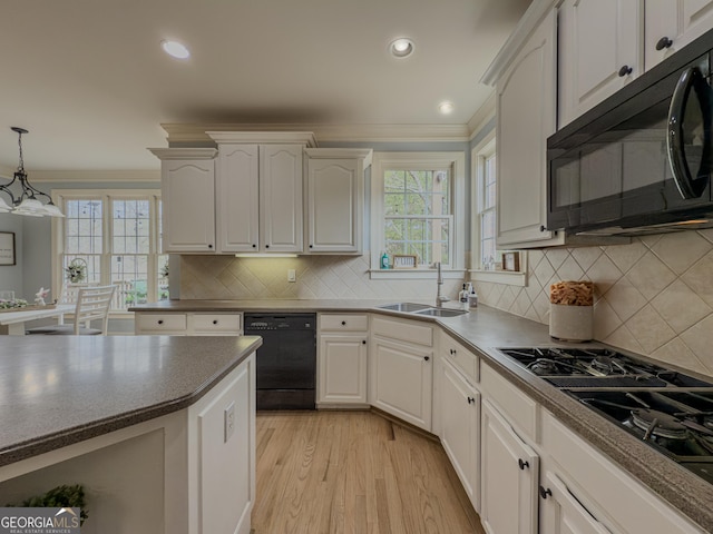kitchen with white cabinetry, black appliances, crown molding, and a sink