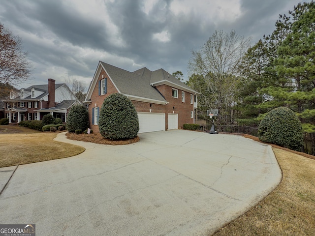 view of home's exterior featuring a garage, brick siding, concrete driveway, and a lawn