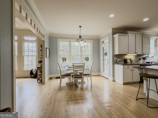 dining space featuring light wood finished floors, baseboards, a chandelier, ornamental molding, and recessed lighting