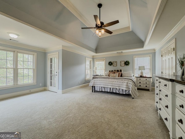 unfurnished bedroom with light colored carpet, crown molding, a tray ceiling, and multiple windows