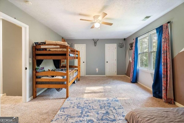 bedroom featuring carpet, baseboards, visible vents, and a textured ceiling