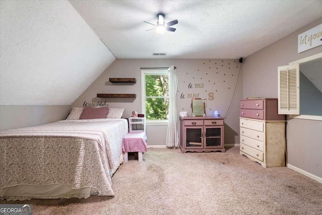 bedroom with baseboards, visible vents, vaulted ceiling, a textured ceiling, and carpet floors