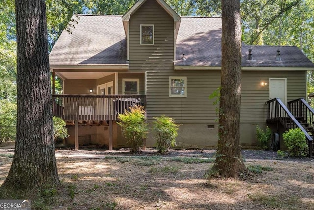 rear view of property featuring crawl space, a shingled roof, and a wooden deck