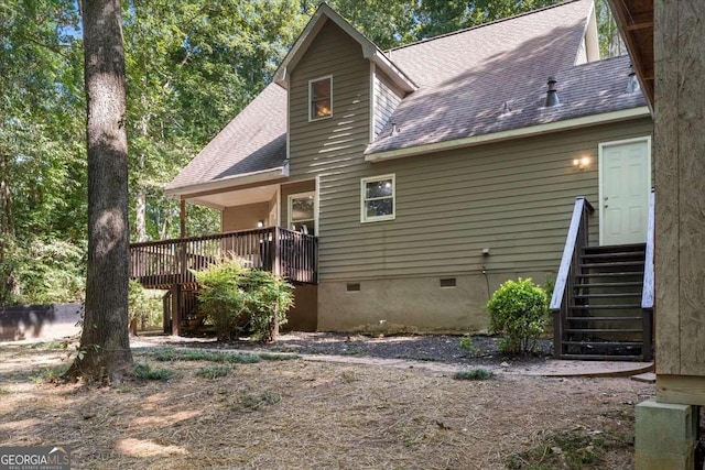 back of property featuring stairway, crawl space, roof with shingles, and a deck