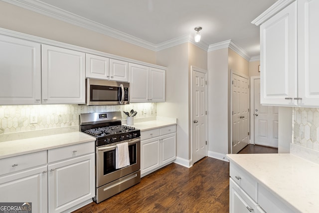 kitchen with backsplash, dark wood-type flooring, crown molding, stainless steel appliances, and white cabinetry