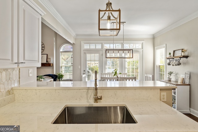 kitchen featuring crown molding, plenty of natural light, and a sink