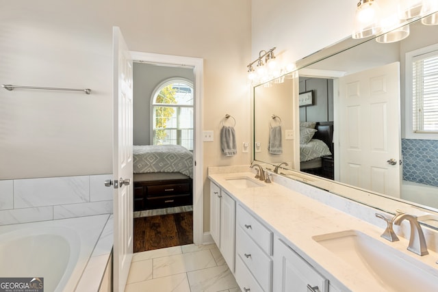 bathroom with double vanity, ensuite bathroom, and a sink