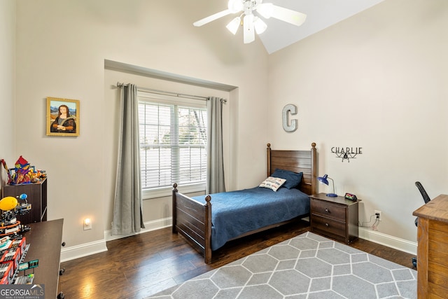 bedroom featuring baseboards, wood finished floors, and vaulted ceiling