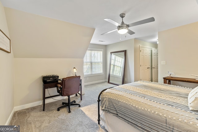 bedroom with light colored carpet, lofted ceiling, baseboards, and ceiling fan