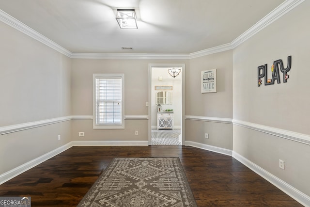 unfurnished room featuring visible vents, ornamental molding, baseboards, and wood finished floors