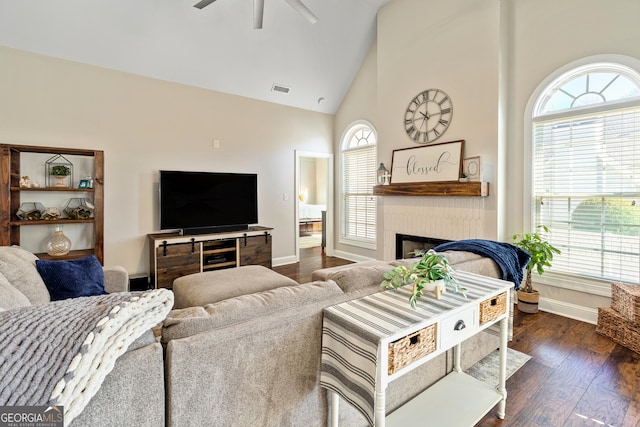 living room with dark wood-style floors, visible vents, high vaulted ceiling, a fireplace, and ceiling fan