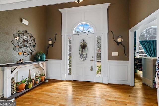 entrance foyer featuring a wainscoted wall and light wood-style flooring