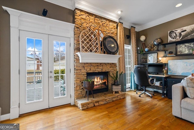 office with a fireplace, ornamental molding, wood finished floors, and french doors