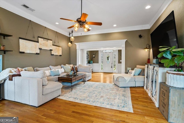 living area featuring ornamental molding, recessed lighting, visible vents, and light wood-style floors