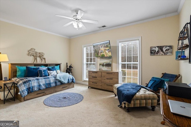 carpeted bedroom featuring a ceiling fan, visible vents, and crown molding