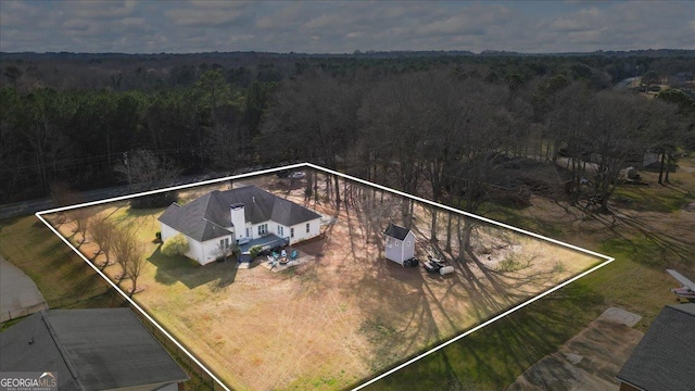 birds eye view of property with a view of trees