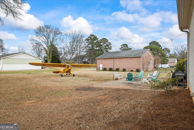 view of yard featuring an outdoor fire pit and a patio