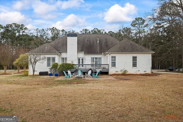 rear view of property with crawl space, a chimney, a lawn, and a wooden deck