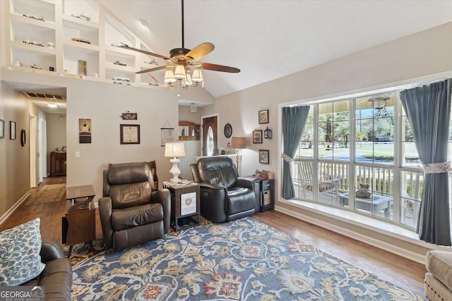 living area featuring ceiling fan, high vaulted ceiling, wood finished floors, visible vents, and baseboards