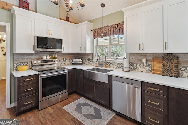 kitchen with white cabinets, stainless steel appliances, a sink, and light countertops