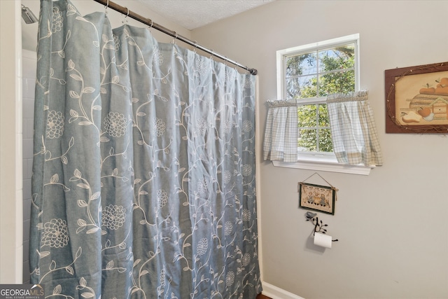 bathroom featuring a shower with curtain and a textured ceiling