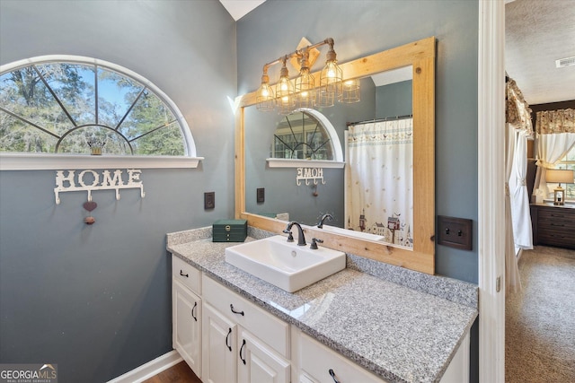 bathroom featuring visible vents, baseboards, and vanity