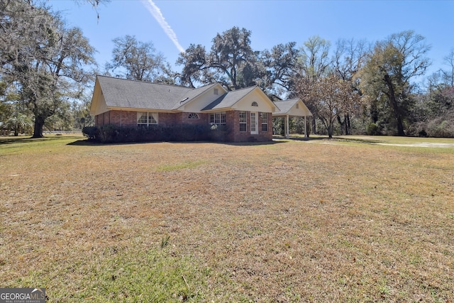 single story home featuring a carport, a front lawn, and brick siding