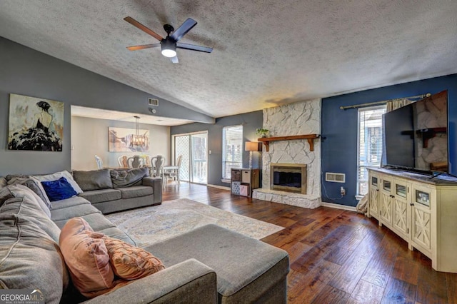 living room featuring lofted ceiling, a fireplace, visible vents, and dark wood-type flooring