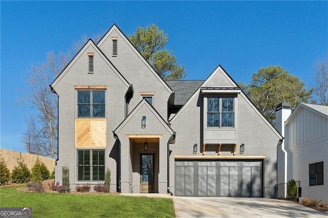 view of front of home featuring concrete driveway, an attached garage, brick siding, and a front yard