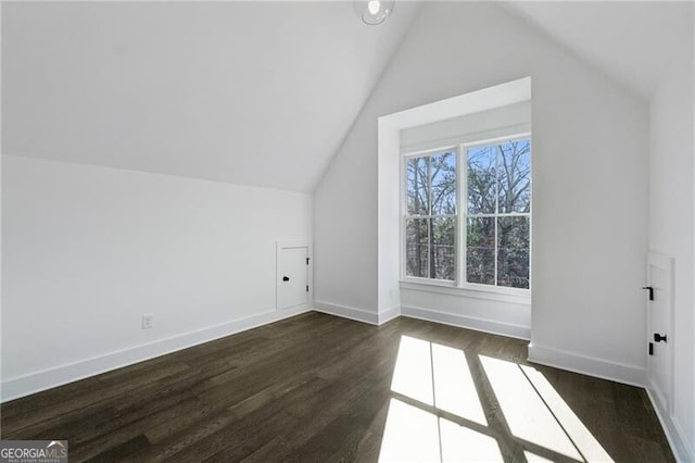 bonus room with vaulted ceiling, dark wood-style floors, and baseboards