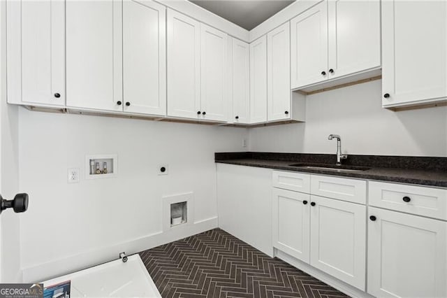 clothes washing area with cabinet space, electric dryer hookup, washer hookup, and a sink